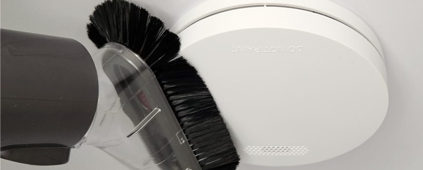 Interconnected smoke alarms cleaning with soft brush attachment from vacuum